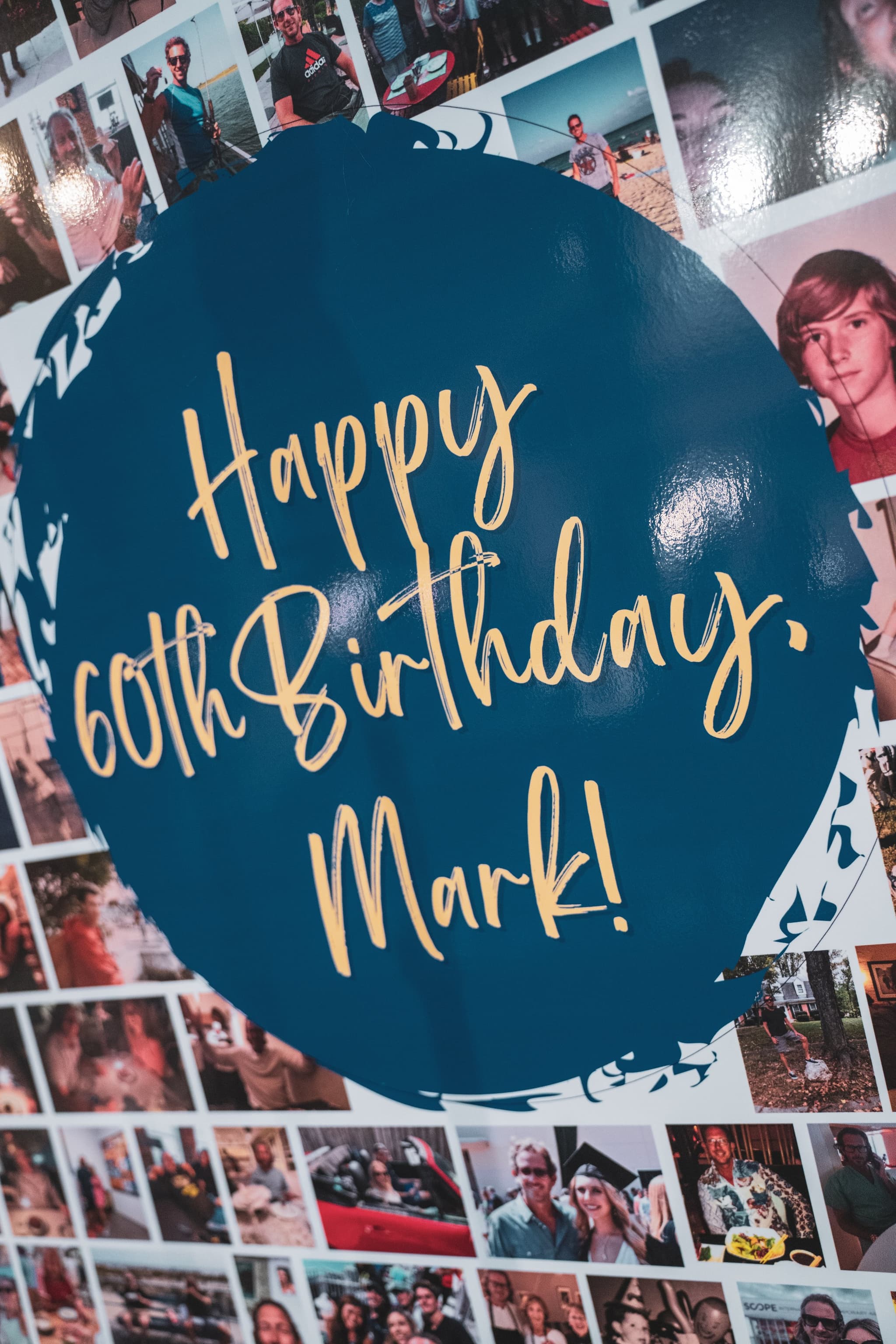 A close-up of a decorated birthday cake topped with a confetti balloon and a gold Happy Birthday cake topper