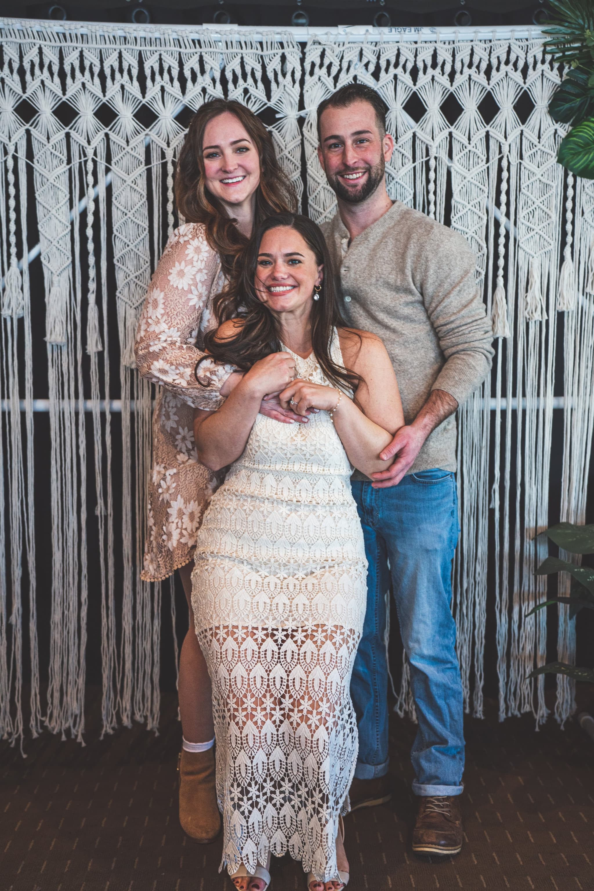 Three-person portrait at macrame backdrop