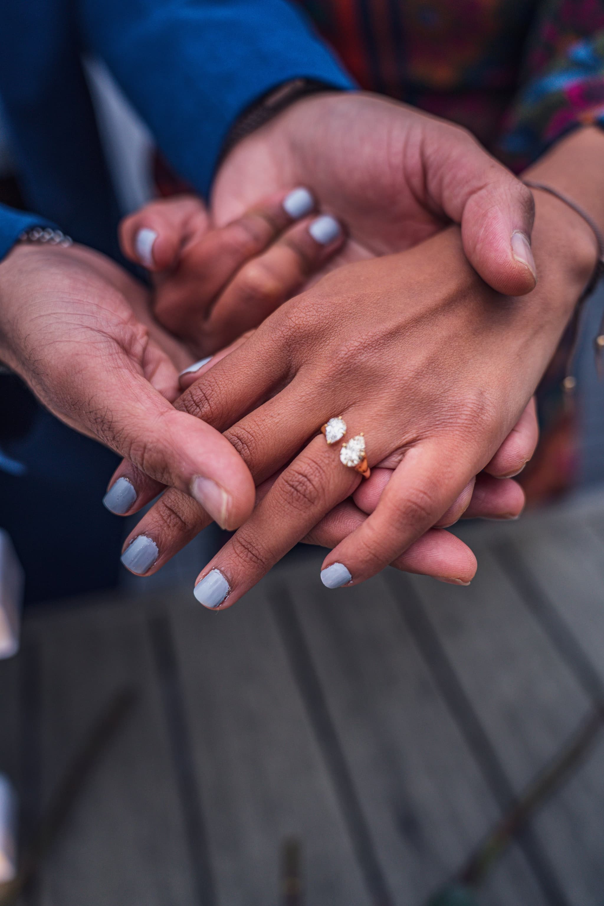 Close-up of couple's hands with engagement ring in focus