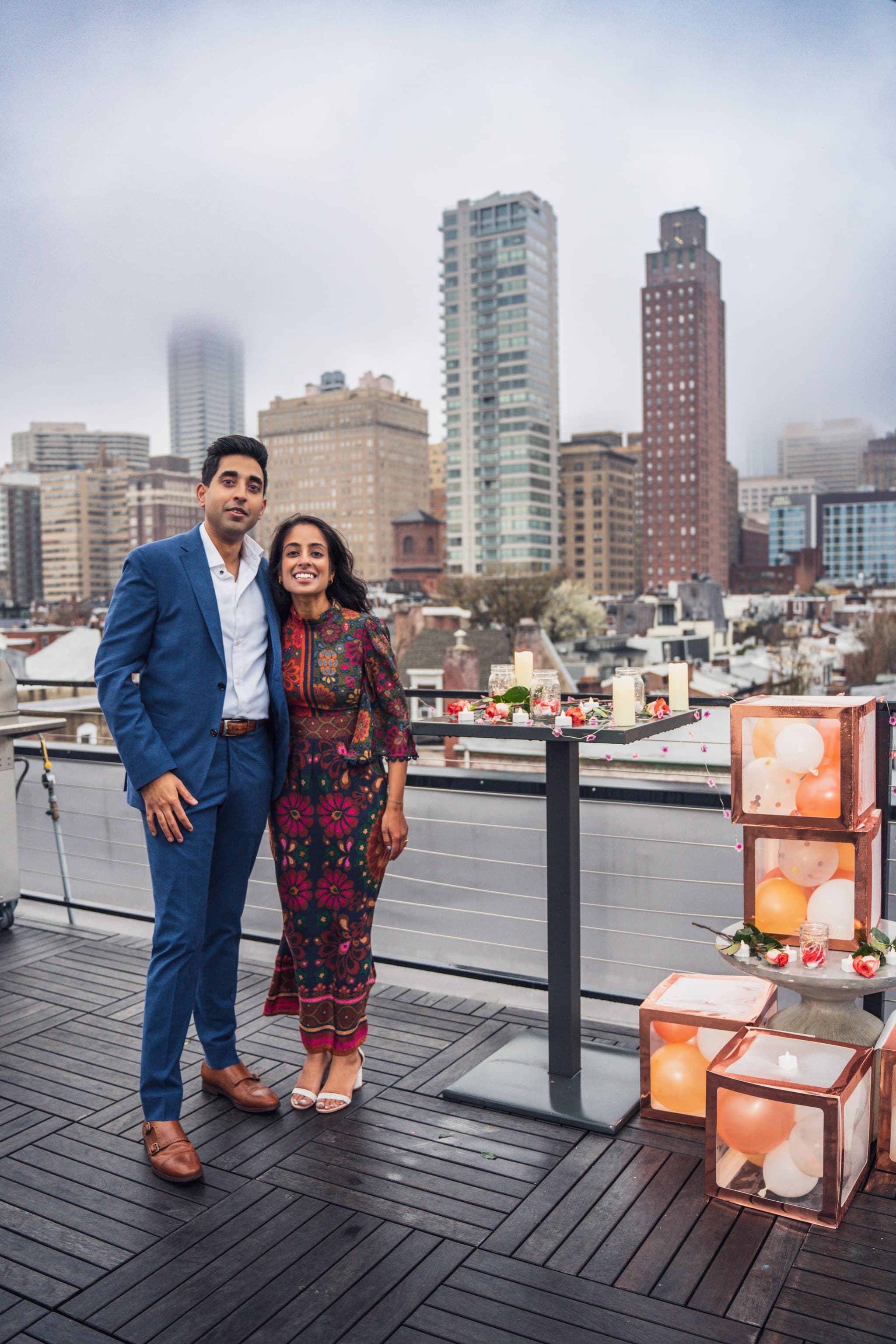 Couple portrait on rooftop with city skyline and glowing lanterns