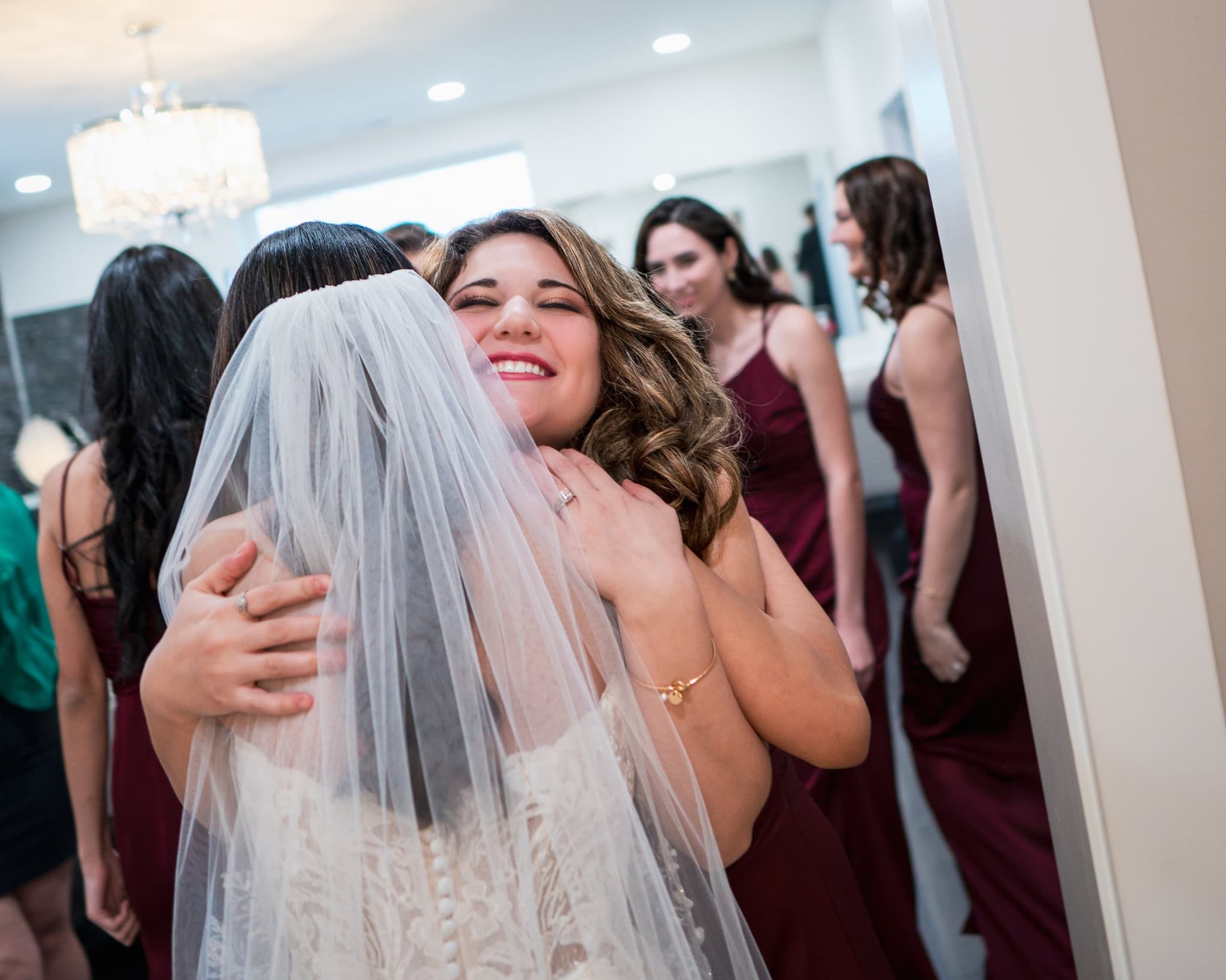A bridesmaid embraces the bride in a heartfelt hug before the ceremony